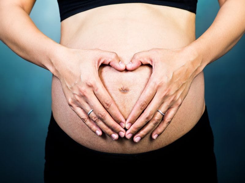 Image of woman with hands in front of her stomach 