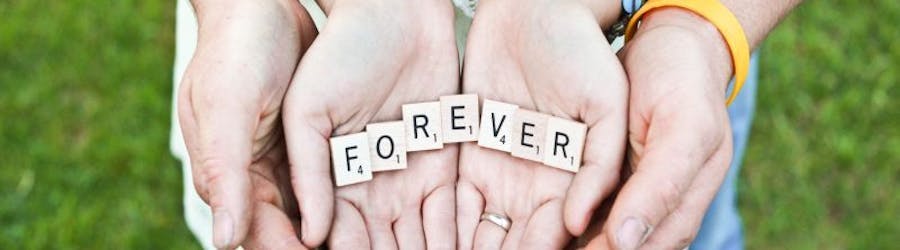 couples hands holding the word forever