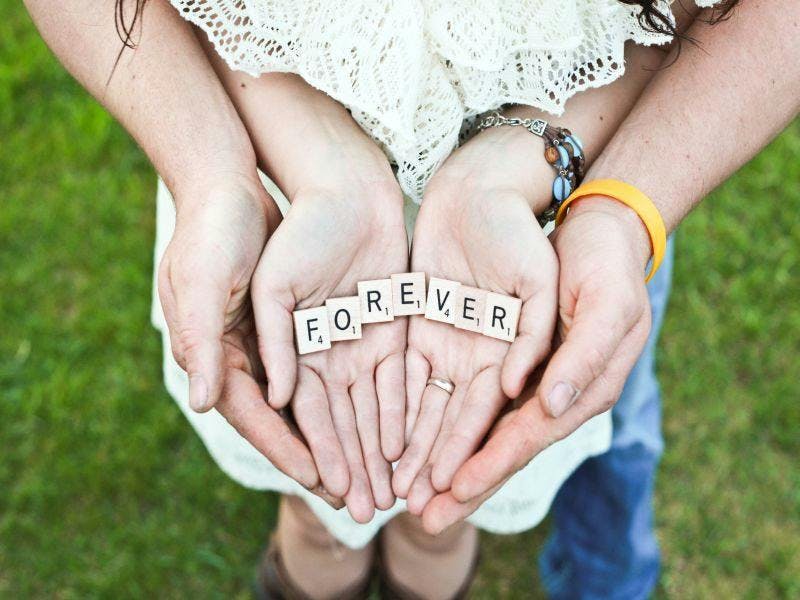 couples hands holding forever word