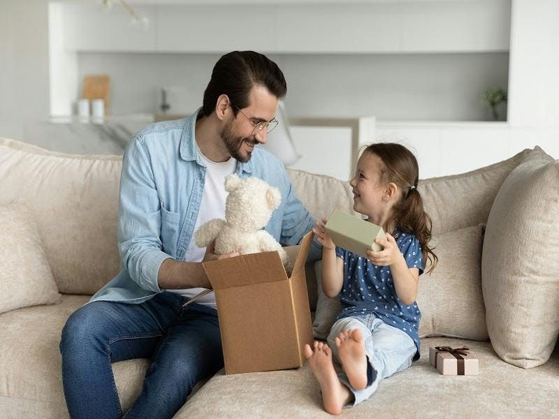 Image of a father and daughter opening a present