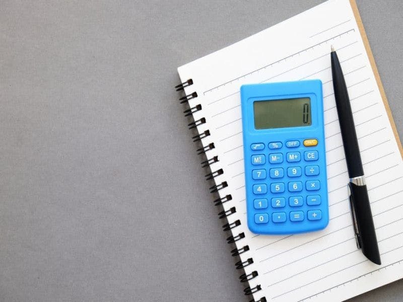 calculator, writing pad and pen