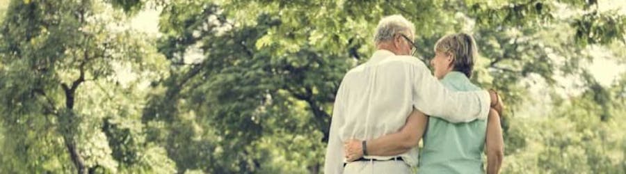 elderly couple walking in park